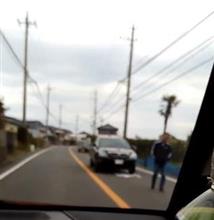 車道を歩いて車を止める歩行者 車道を歩いて車を止める歩行者
